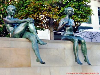 Nackte Frauen auf einer Mauer