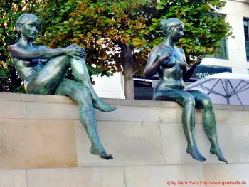 Nackte Frauen auf einer Mauer